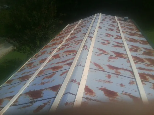 Rusted metal roof panels with new wood purlins before replacement — Storm Damage Roof Repair in Conehatta by Roofing Brothers